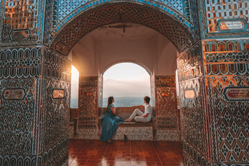 Couple sitting and admiring the view from above at Mandalay Hill, Myanmar during sunset.