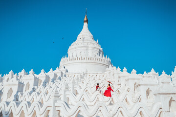 A couple visits the white Hsinbyume Pagoda during sunset in Myanmar.