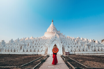 Young woman visits the white Hsinbyume Pagoda during sunset. in Myanmar.