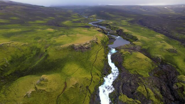 Eldgja Canyon Beautiful Remote Landscape Iceland. Long Drone Flight Backwards to Reveal Colorful Moody Fog Scene of Canyon, River, Breathtaking Waterfall. 4K High Quality Color Corrected.