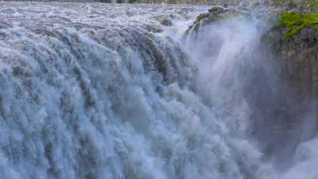 Dettifoss Slow Motion Waterfall Full Force Close Up. Epic Massive Waterfall in Iceland Flows Daytime Summer in Iceland Hand Held Camera.