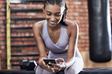 Happy woman, fitness and browsing with phone at gym for online search on workout or exercise. Young...
