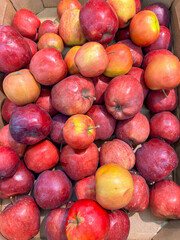 Ripe red apples on a counter in a market as a background. Texture