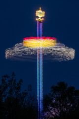 evening in an amusement park - a spinning tall illuminated carousel