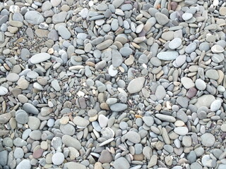 Pebbles on the beach stone rock texture gravel stones pattern abstract nature smooth gray pebbles. Pebbles on the beach sea textured backgrounds white surface granite rocks grey material. 