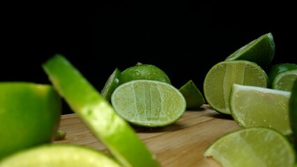 Close-up, a vibrant slice of fresh lime rests upon a rustic wooden cutting board, exuding freshness...