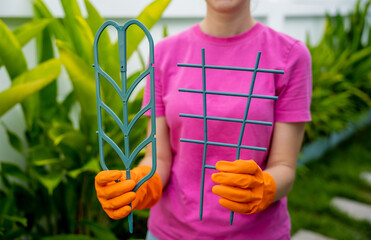 A young woman takes care of the garden and tying up plants - 790586847