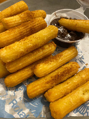 close up hand hold churros with chocolate sauce