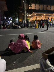 three little girl sit on the street at night