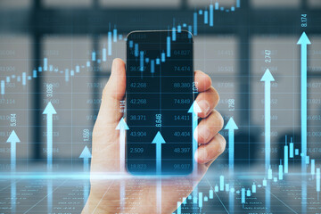 Close up of male hand holding smartphone with growing blue vertical arrows and candlestick forex...