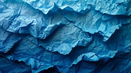   A vast blue expanse of paper, resembling mountain ranges after being folded - obrazy, fototapety, plakaty
