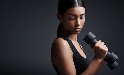 Indian woman, dumbbells and weightlifting in studio for training on black background, lose weight...