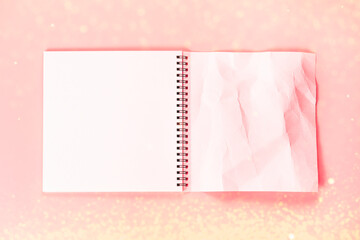 Open notebook with whole page and rumpled. An empty layout template for spiral notebook on pink background with sparkles.