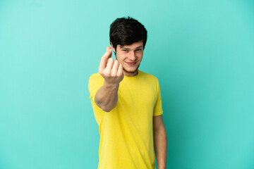 Young Russian man isolated on blue background making money gesture