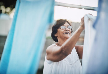 Mature woman, clothesline and laundry in garden with household domestic chores, spring cleaning and...