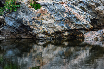 Crystal clear waters reflecting the vibrant sky and rocks.