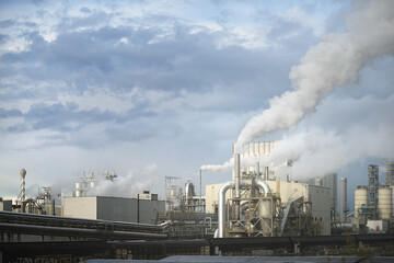 Industrial Factory Emits Smoke Against Cloudy Sky