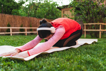 One young caucasian woman is doing yoga and stretching in backyard	
