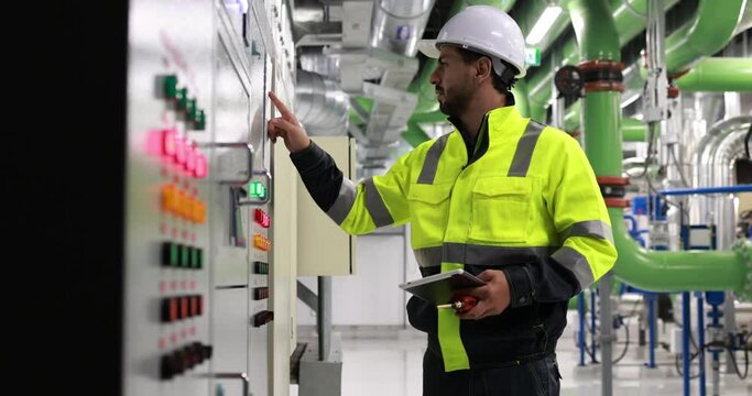 Industrial engineer or electrical engineer with PPE check control panel in HVAC control room, Industrial  Factory