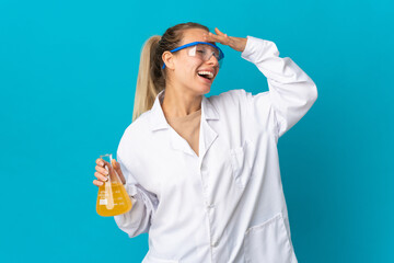 Young scientific woman isolated on blue background smiling a lot