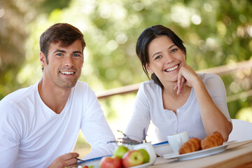 Couple, breakfast and outdoors portrait for eating, love and affection in marriage or romance in nature. People, nutrition and smile at home for healthy relationship, food and relax on vacation