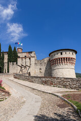The stone drawbridge entrance to the medieval Brescia Castle in Lombardy, with the Mirabella Tower...