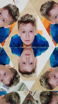 Curious boy in blue and yellow shirt reflecting in the mirrors of kaleidoscope. Abstract montage of a child in many triangle parts of the kaleidoscope. Vertical video