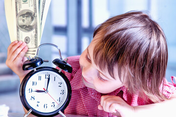 Time is money. Humorous portrait of cute little business child girl holding a clock and US Dollars in office. Horizontal image.
