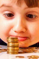 Happy beautiful little business child girl sniffs coins. Purposefulness, motivation, wealth, success, freedom concept. Vertical image.