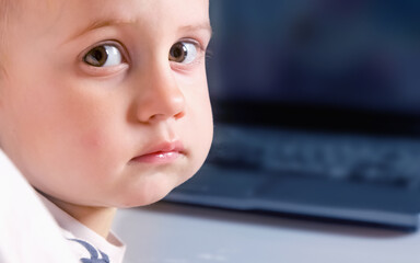 Portrait of beautiful baby watching computer at home. Copy space for text or design. - 790641496