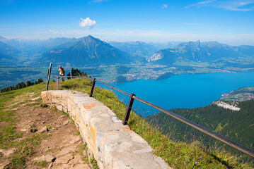 hiker at Niederhorn mountain summit, view to lake Thunersee and Bernese Alps - 790642289