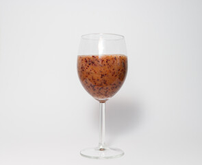 Blue berry smoohie in wine glass against white background