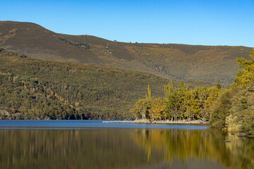 Sanabria Lake Natural Park in autumn at sunset with the mountains reflected in the water, Zamora, Castilla y León, Spain.