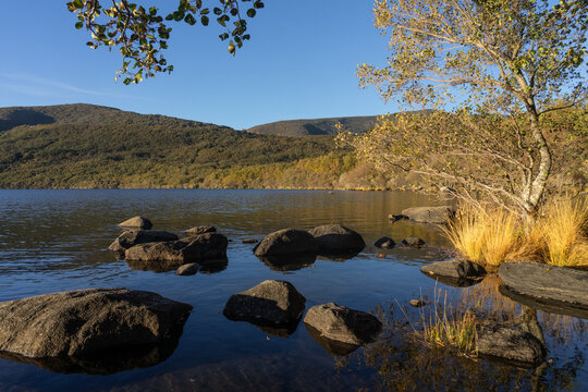 Sanabria Lake Natural Park in autumn at sunset with the mountains reflected in the water, Zamora, Castilla y Le&oacute;n, Spain.