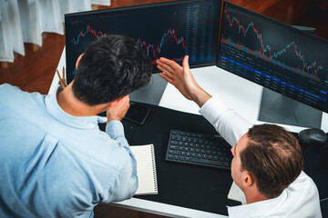 Business professional brokers discussing stock market on pc screen in real time, analyzing dynamic...