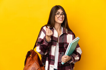 Young student woman isolated on yellow background making money gesture