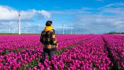 A lone figure stands gracefully amidst a vast field of vibrant purple flowers under the gentle...