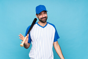 Young man playing baseball over isolated blue background smiling