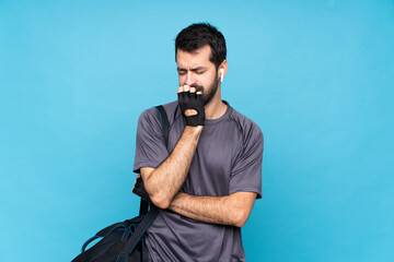 Young sport man with beard over isolated blue background having doubts