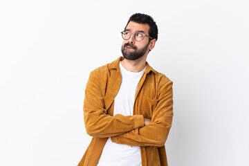 Caucasian handsome man with beard wearing a corduroy jacket over isolated white background with...