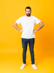 Full-length shot of man with beard over isolated yellow background angry