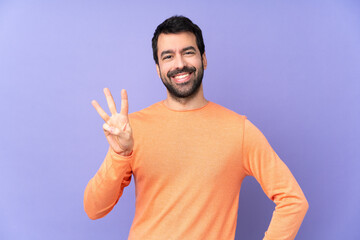 Caucasian handsome man over isolated purple background happy and counting three with fingers