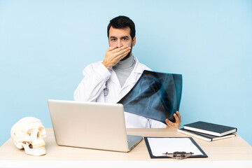 Professional traumatologist in workplace covering mouth with hands