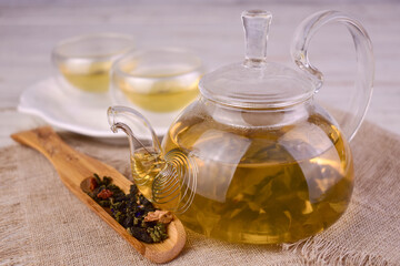 Green tea in a glass teapot. Warm drinks concept.

