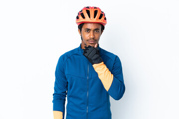 Young cyclist man with braids over isolated background thinking