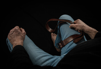 Strict man with leather belt. - obrazy, fototapety, plakaty