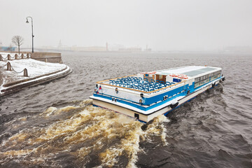 Pleasure boat on the Neva river in a spring snowstorm. St. Petersburg.