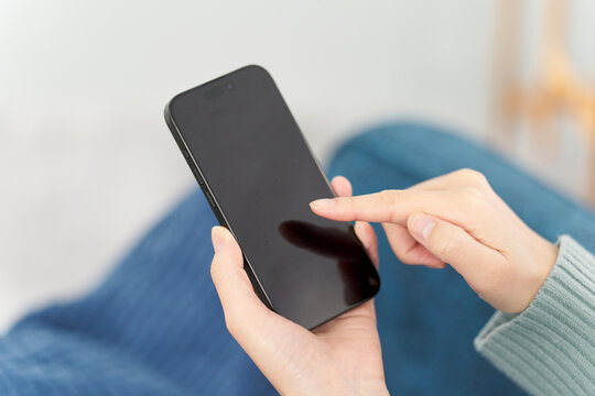 リビングでスマートフォンを操作する女性
