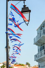 Local flags and ensign in Spetses island during the festivities for the most popular local festival, the Armata. The Greek flag and the local flag of the island are on display.