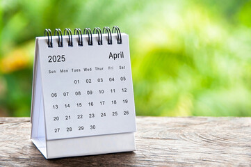 April 2025 white table calendar with customizable space for text. Calendar concept and copy space.